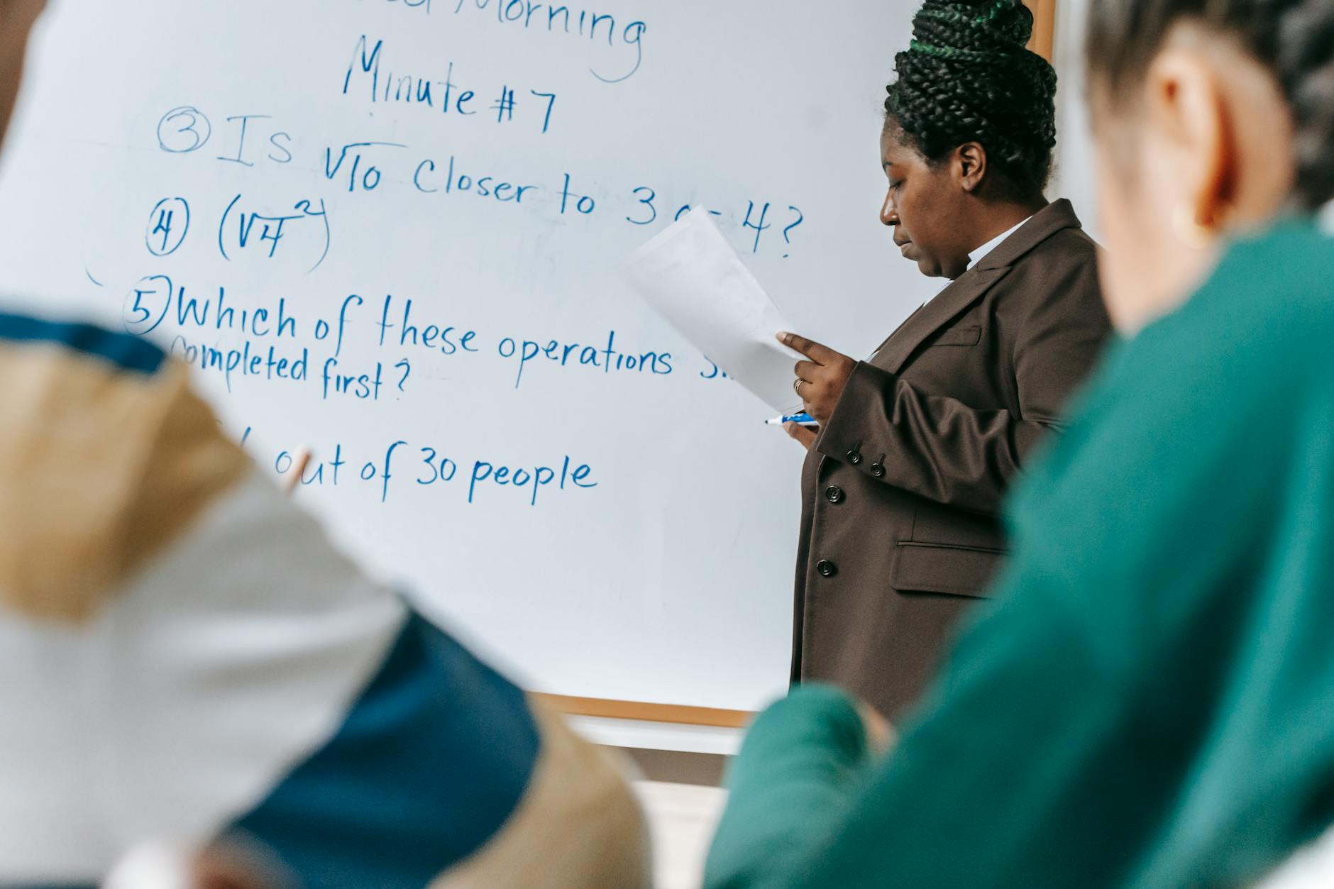 Formatore alla lavagna durante un corso per adulti in aula