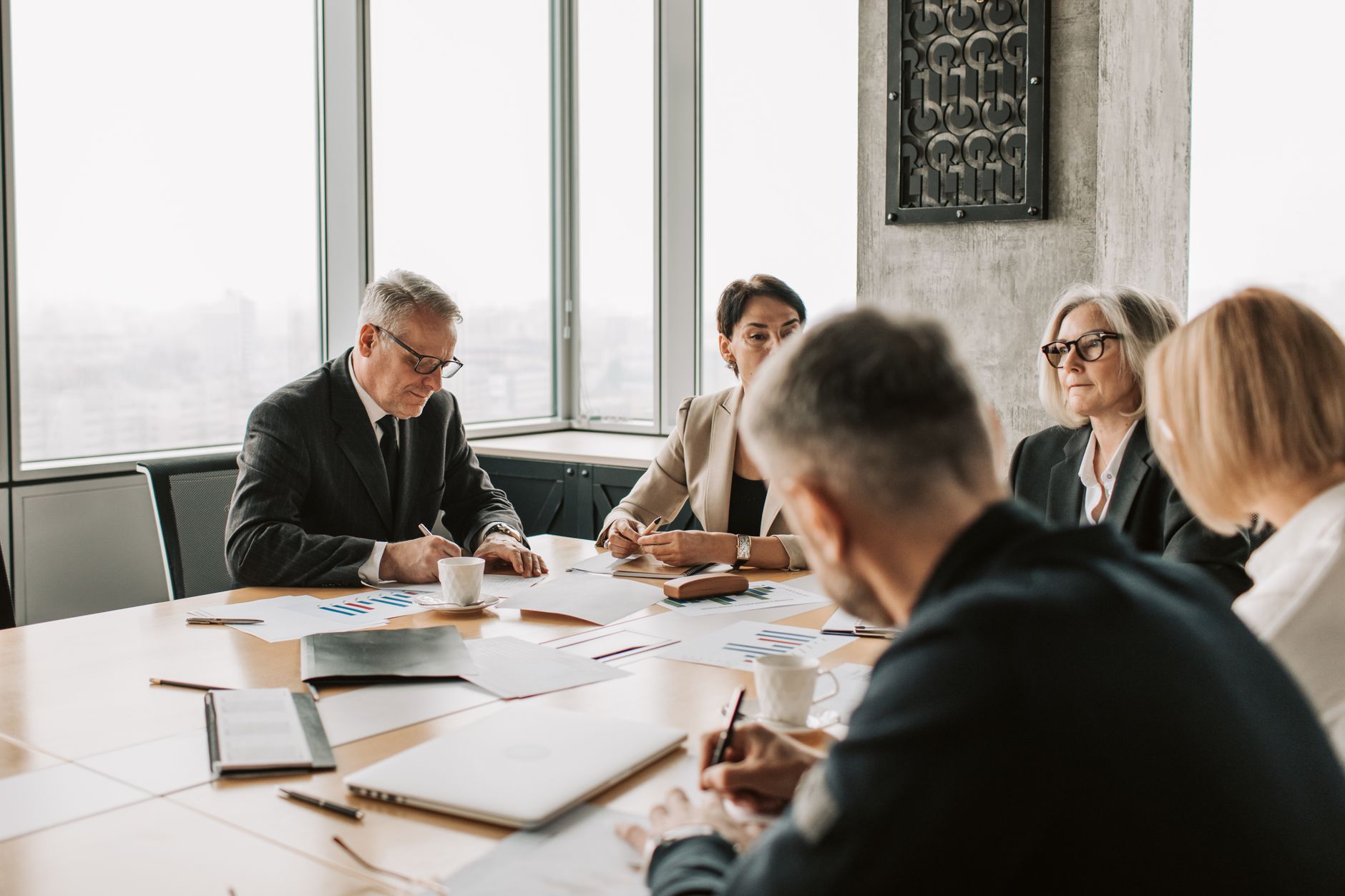 Riunione del board con DPO interno che illustra rischio privacy ai dirigenti aziendali