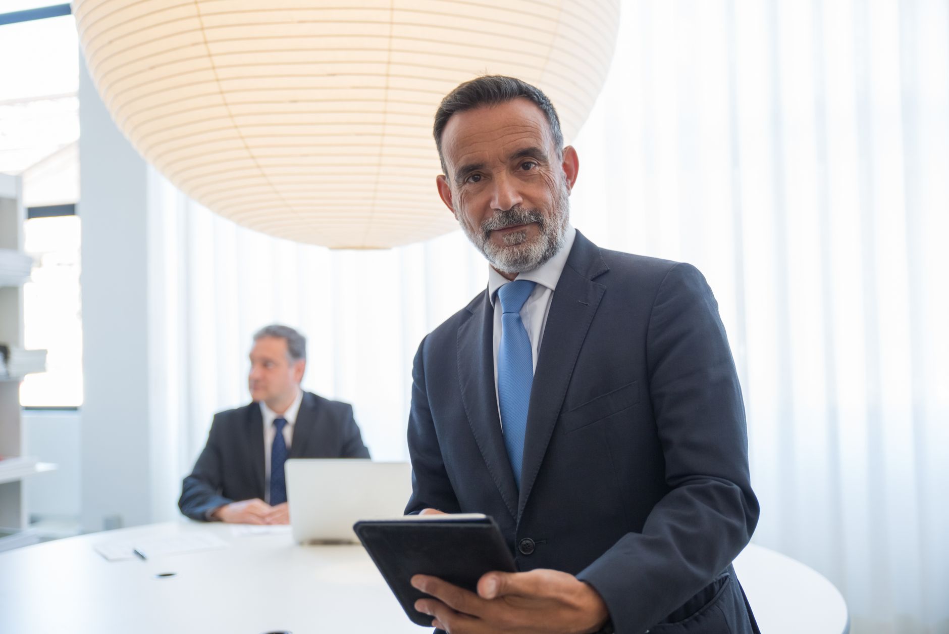 Consulente DPO esterno con tablet che spiega adempimenti GDPR al cliente PMI