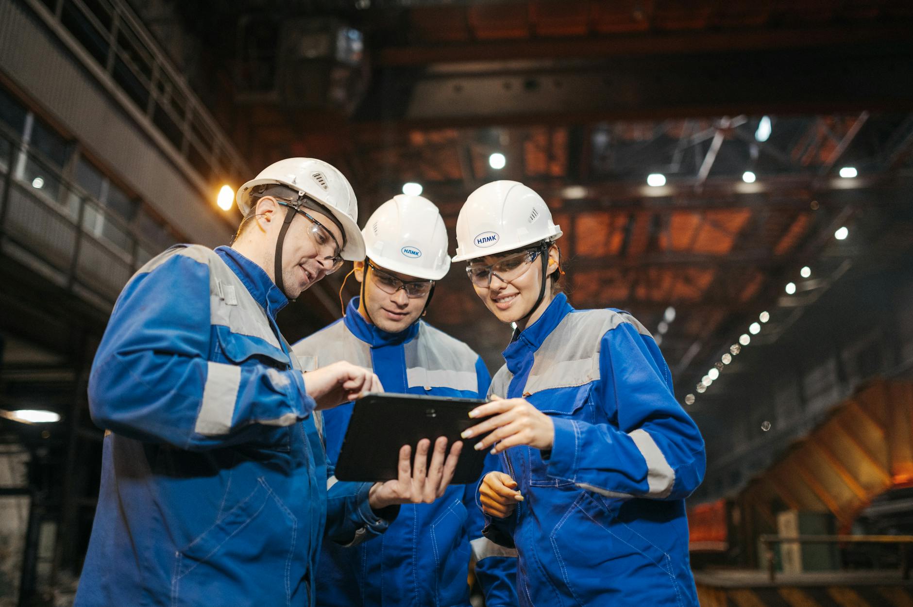 Tecnico sostenibilit&agrave; con tablet che presenta dati ESG in ambiente industriale