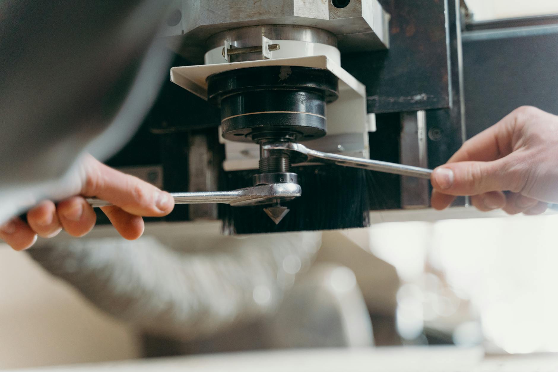 Operatore CNC interagisce con il pannello di controllo di una fresatrice, capacity planning MRP II