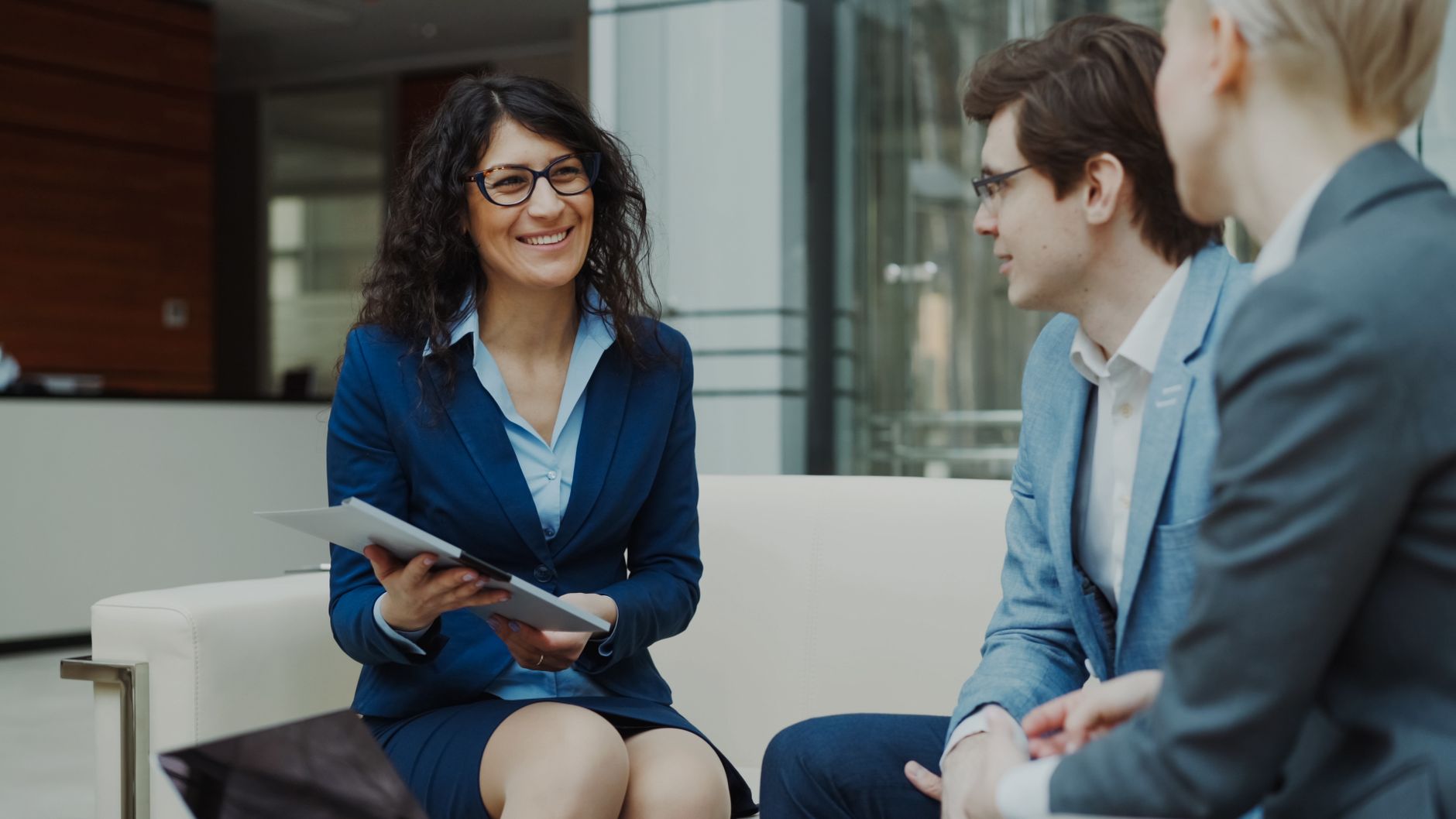 Consulente che spiega normativa compliance al CFO con tablet in ufficio luminoso
