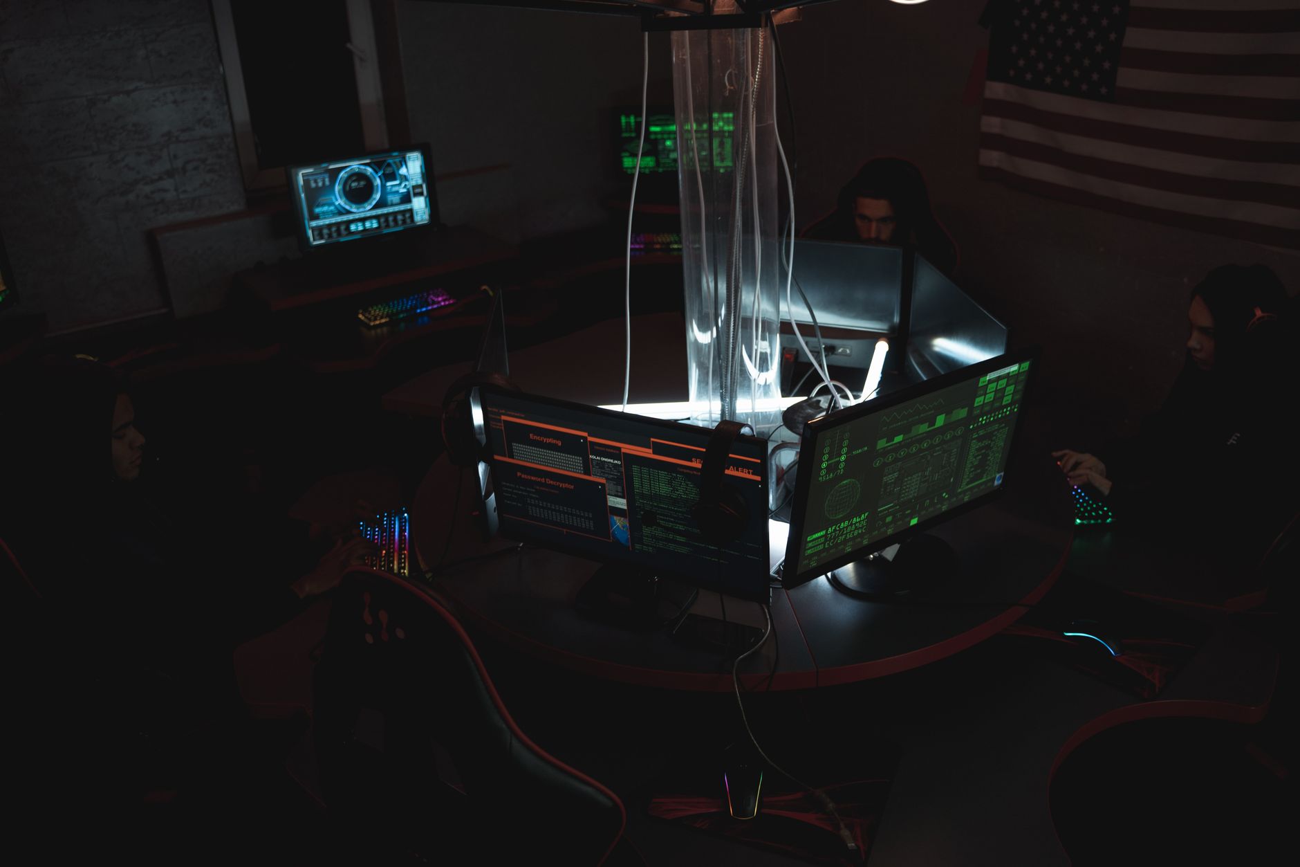Sysadmin che monitora pi&ugrave; schermi con grafici di infrastruttura e rete in NOC operativo