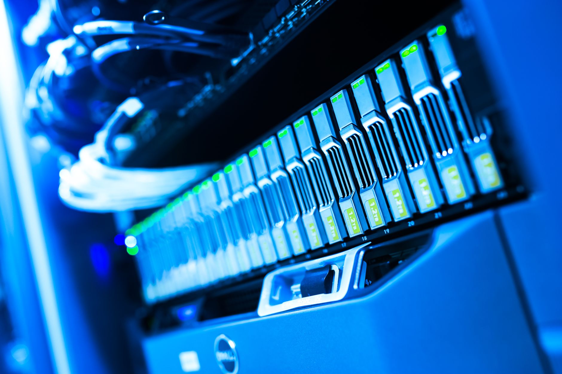 Engineer in a modern datacenter checking server racks with blue LED lighting