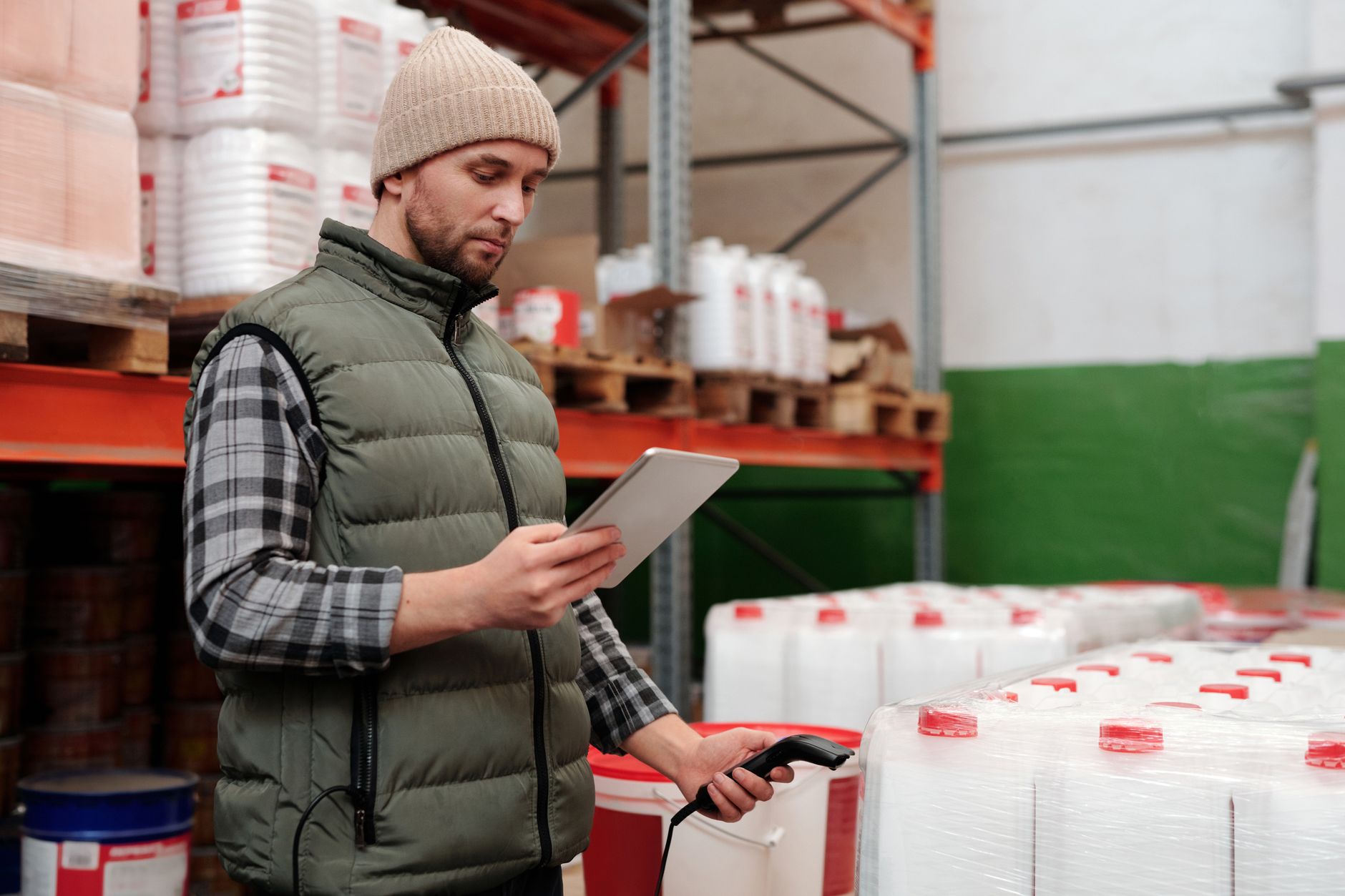 Operatore magazzino con palmare barcode che scansiona scatole sugli scaffali