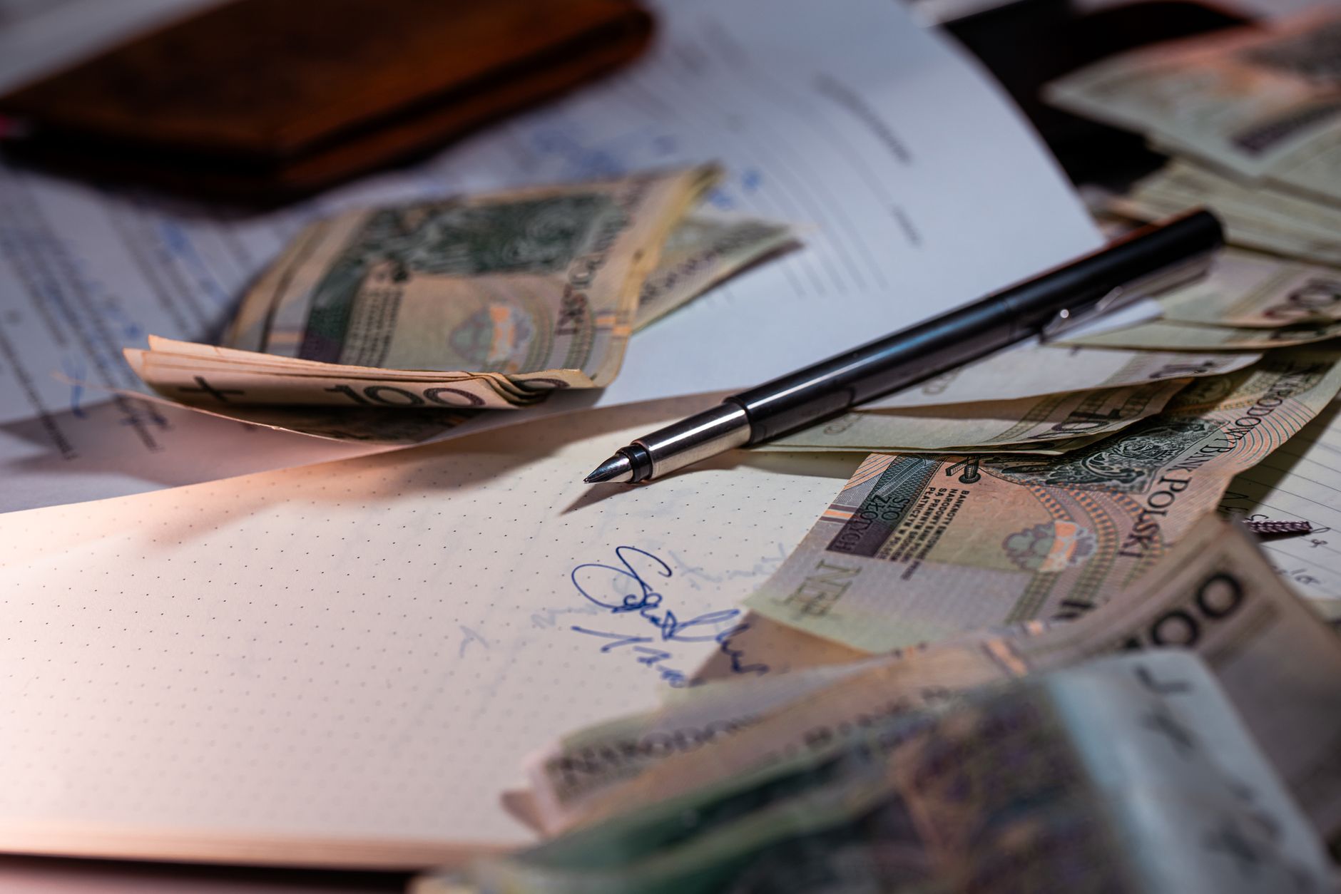 Commercialista italiano firma documenti fiscali alla scrivania con penna