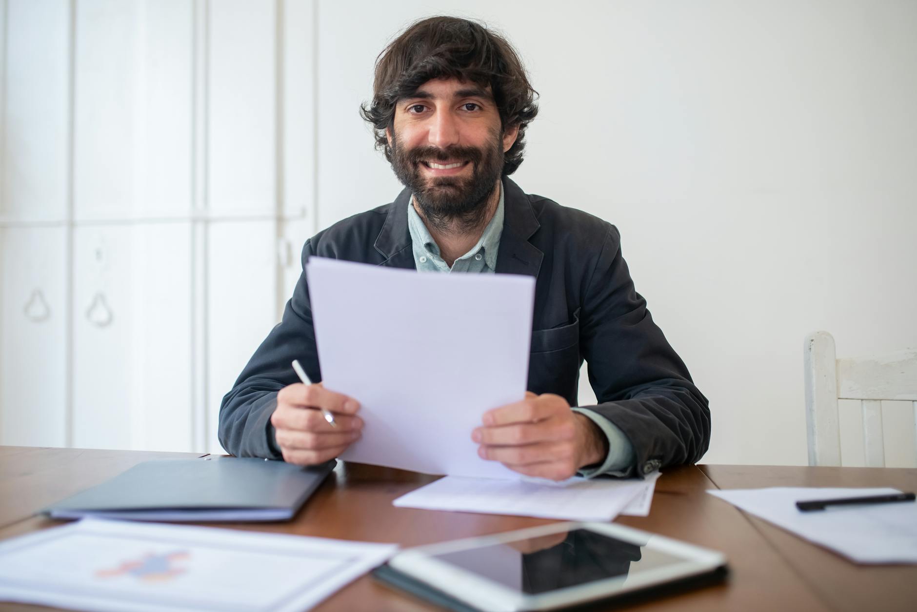 Responsabile risorse umane esamina documenti contrattuali alla scrivania, preparazione degli accordi individuali ex Legge 81/2017