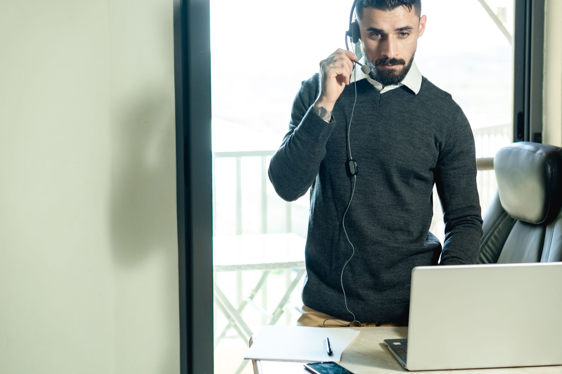 Account manager B2B italiano gestisce una chiamata di vendita su laptop in ufficio