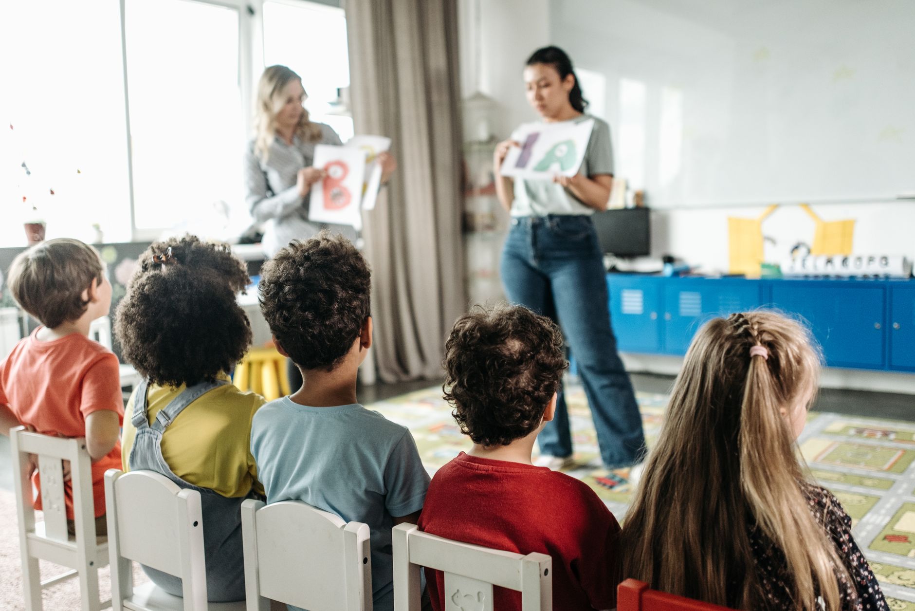 Educatrice in comunicazione con genitori in un asilo nido