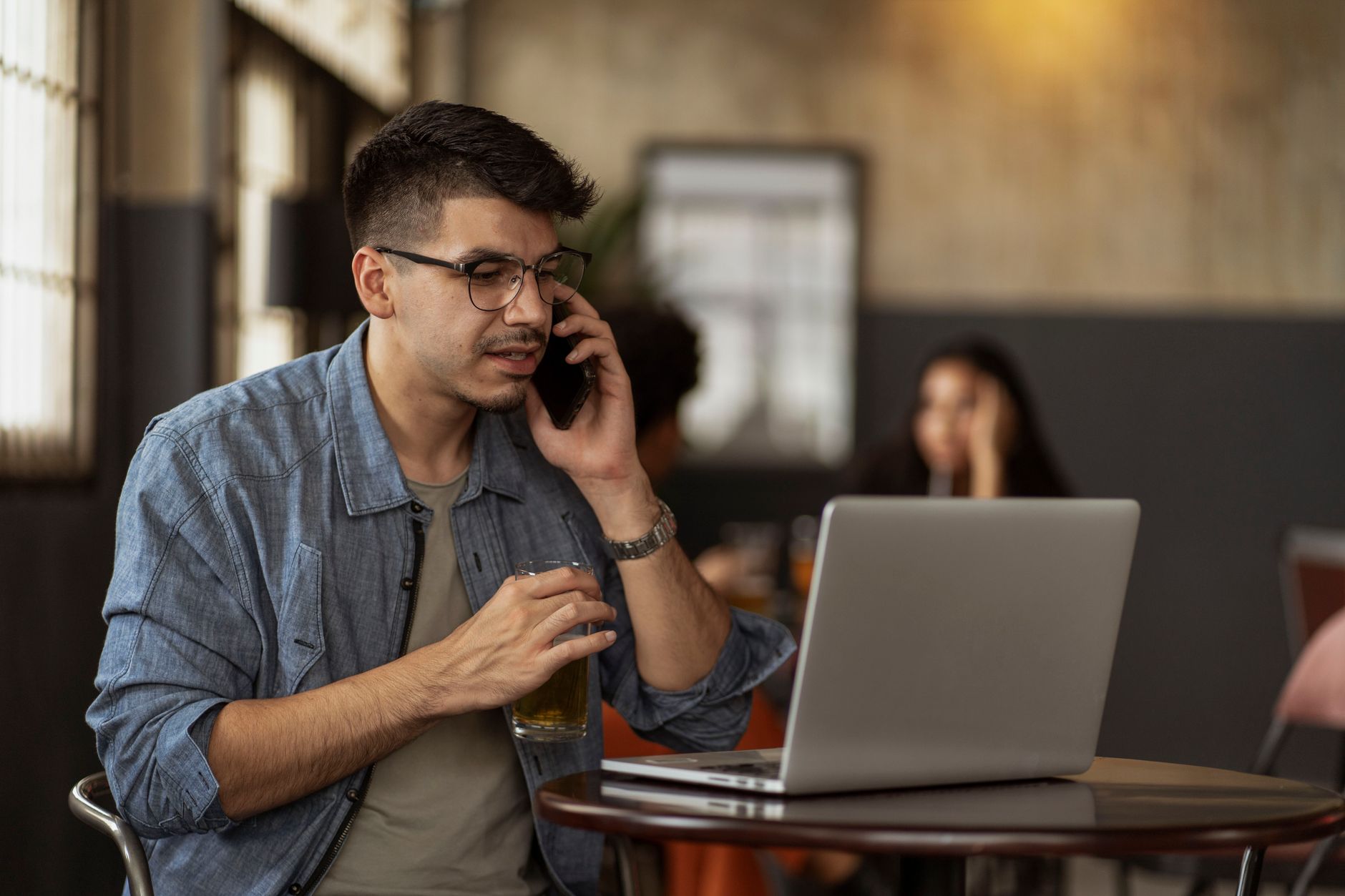 Cliente al telefono con laptop interagisce con assistente NLP