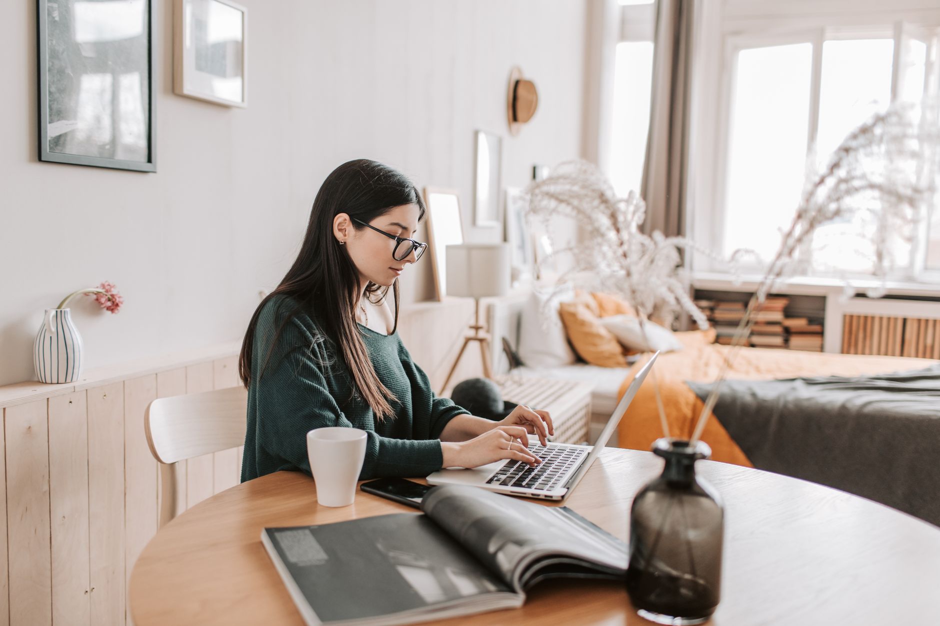 Donna scrive newsletter al laptop in ufficio luminoso