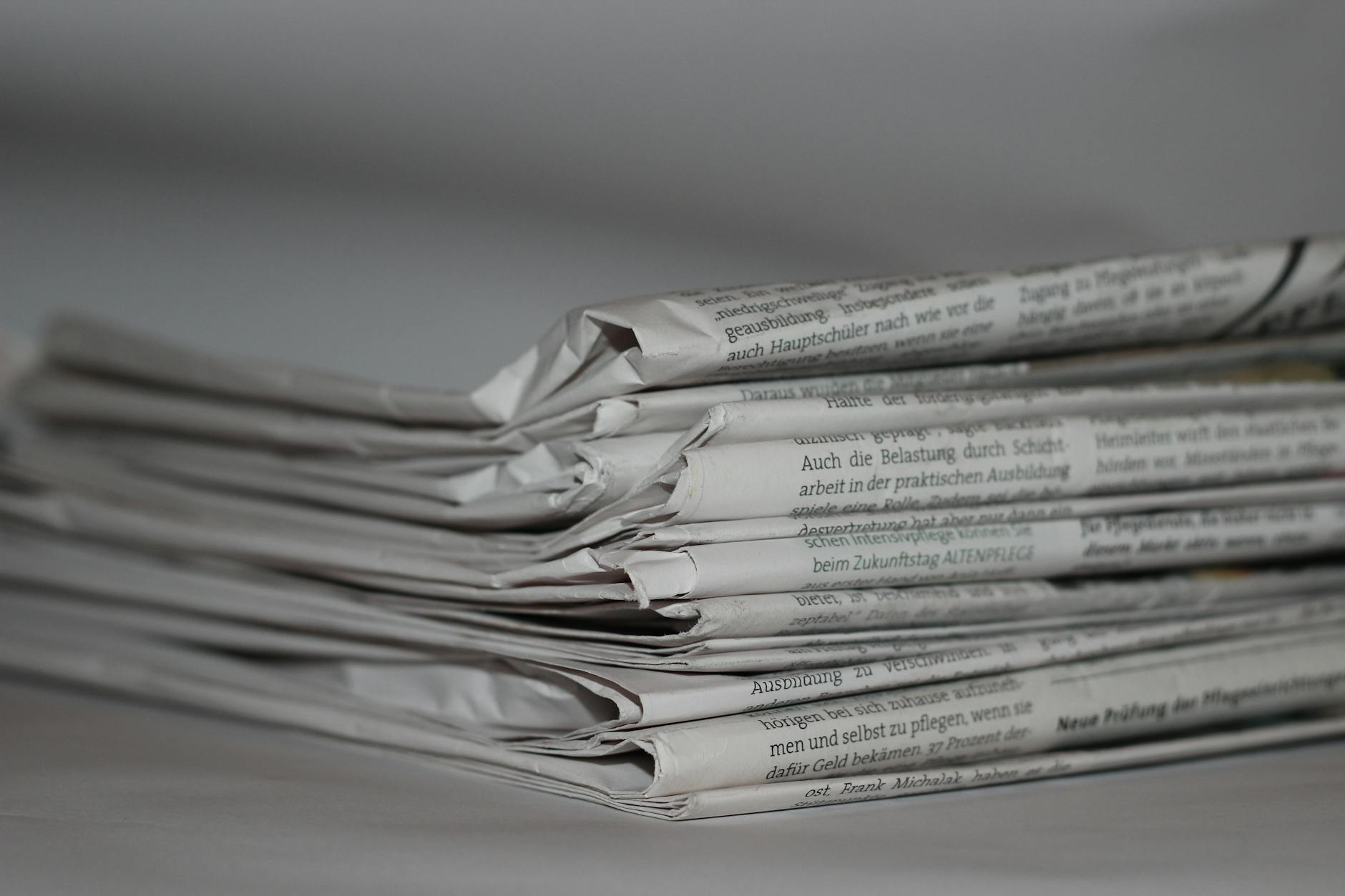 Edicola con quotidiani italiani impilati: la stampa quotidiana e periodica registrata è uno dei canali ammissibili al bonus pubblicità 2023
