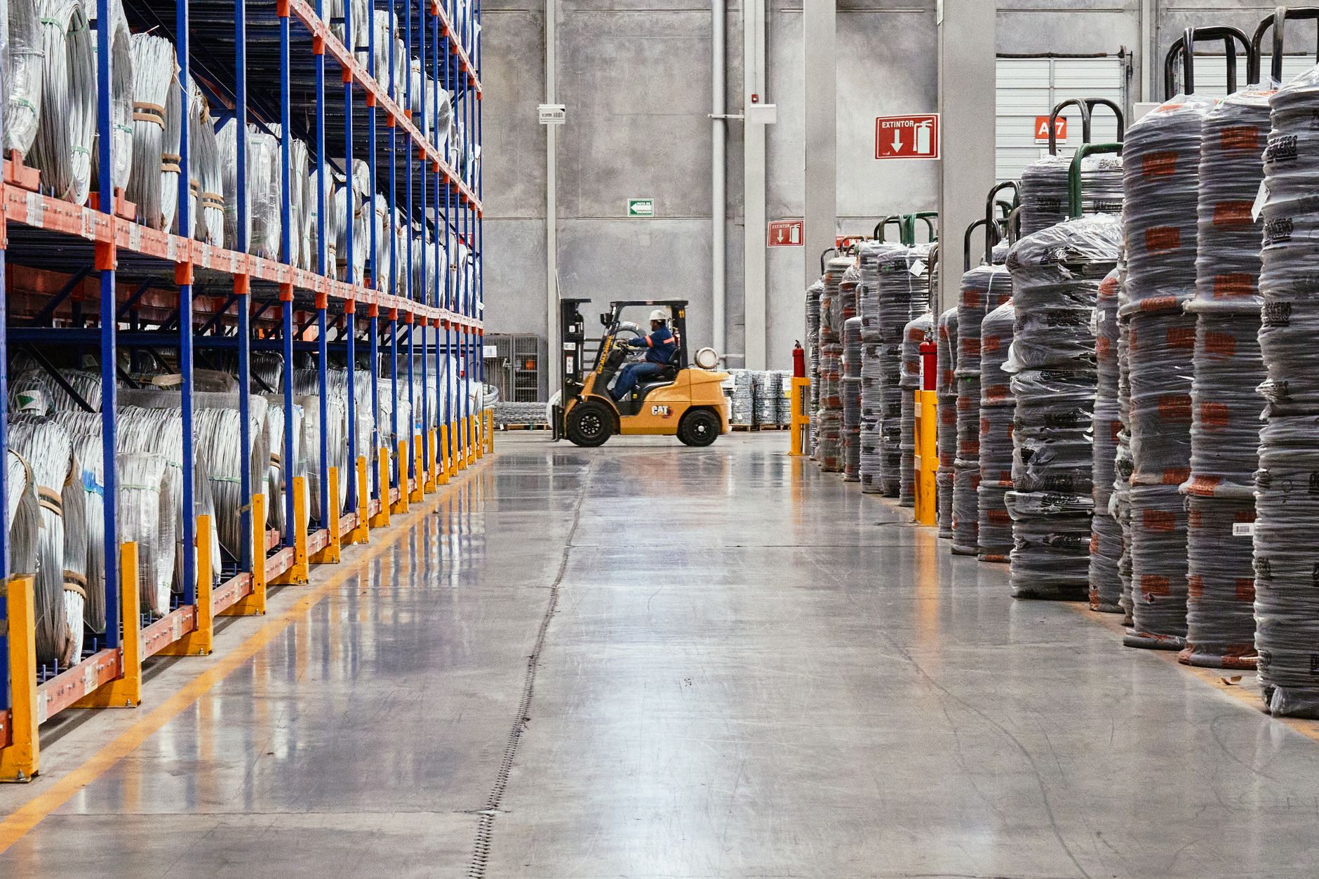 Carrello elevatore in azione tra le corsie di un magazzino industriale durante la movimentazione delle palette