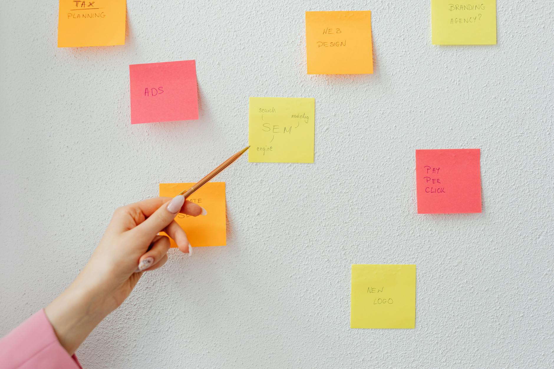Team in piedi davanti a una parete di sticky notes durante una sessione di retrospettiva agile