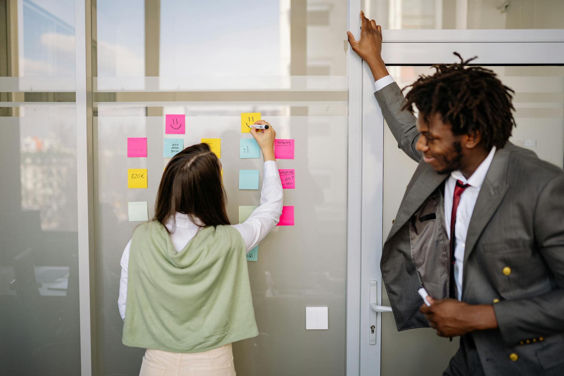 Team QA in retrospective con sticky notes sul muro e kanban board