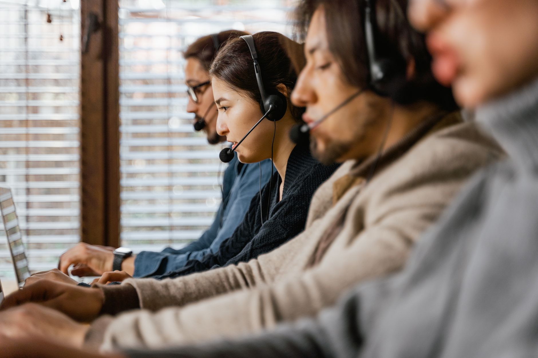 Inside sales con cuffie durante cold call B2B davanti a laptop in ufficio