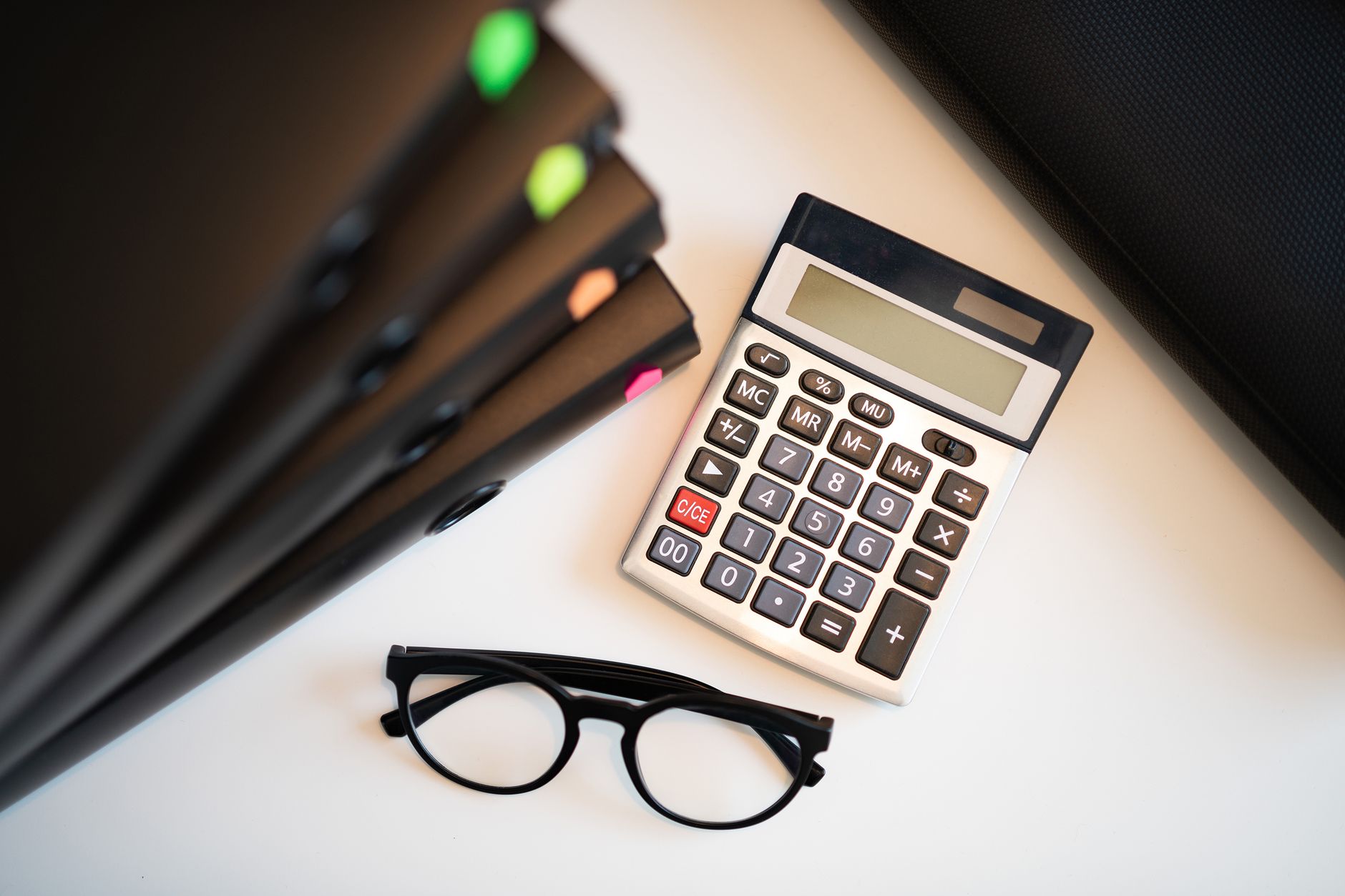 Calcolatrice e documenti fiscali su scrivania: calcolo della flat tax incrementale 15% e novità tributarie 2023