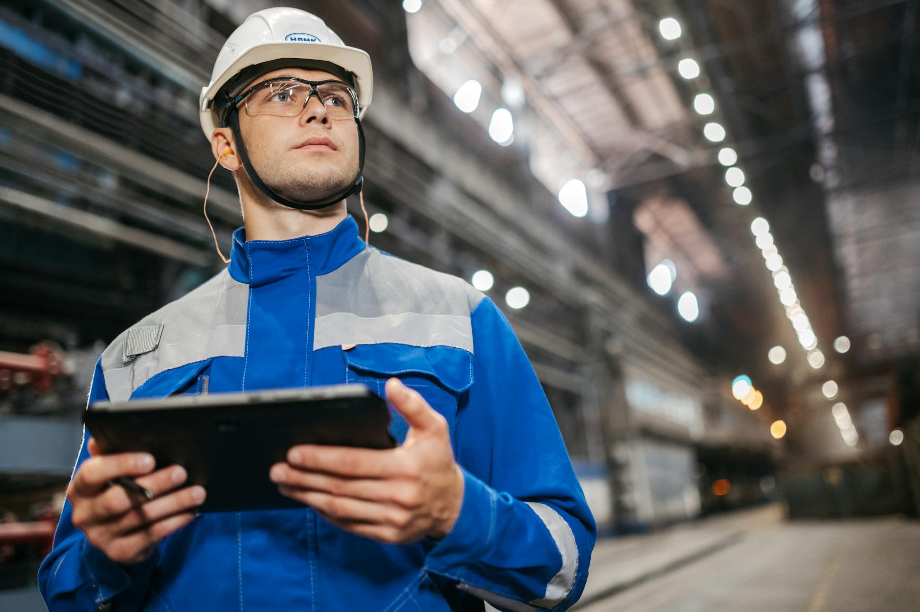 Tecnico manutentore con tablet rileva dati OEE da macchinario