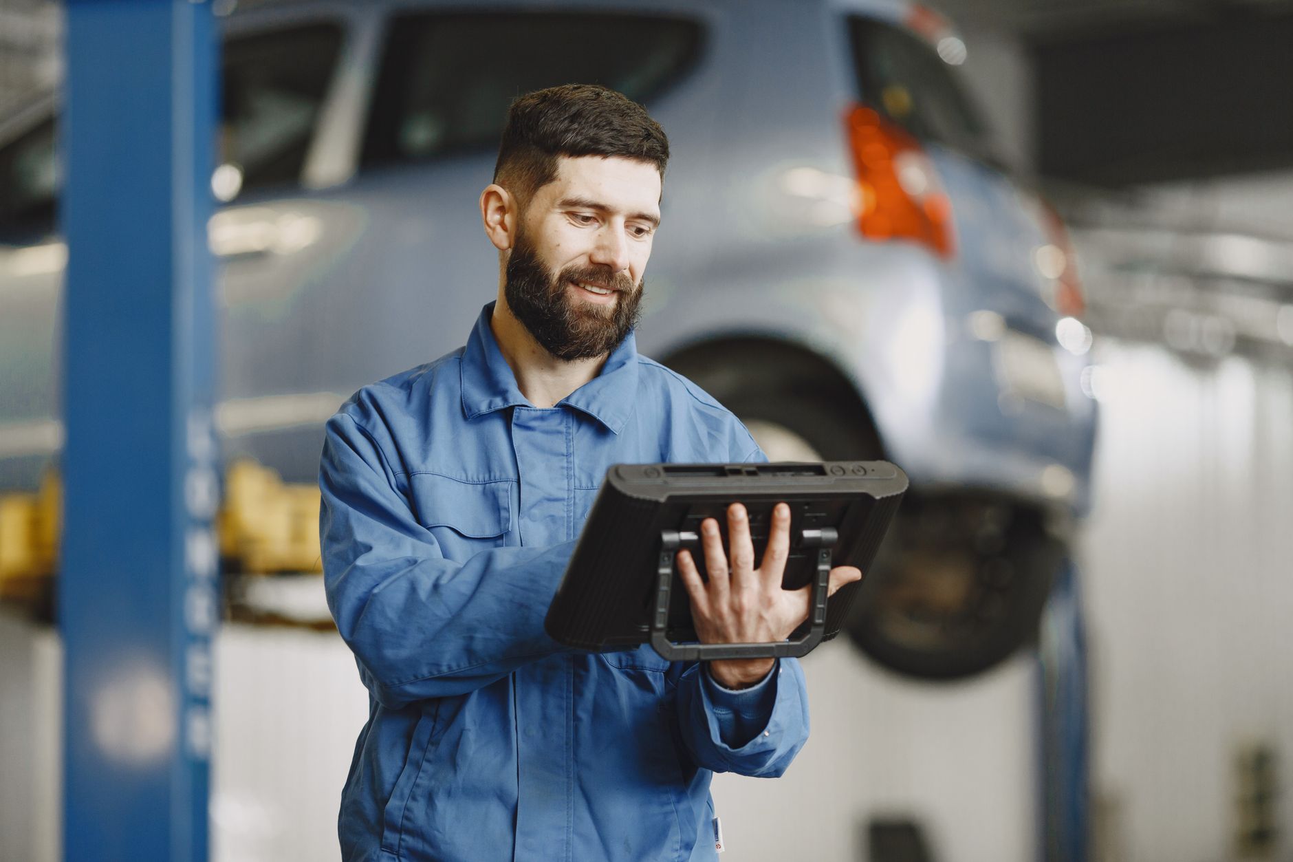 Meccanico con tablet per diagnostica OBD-II in officina autoriparazione