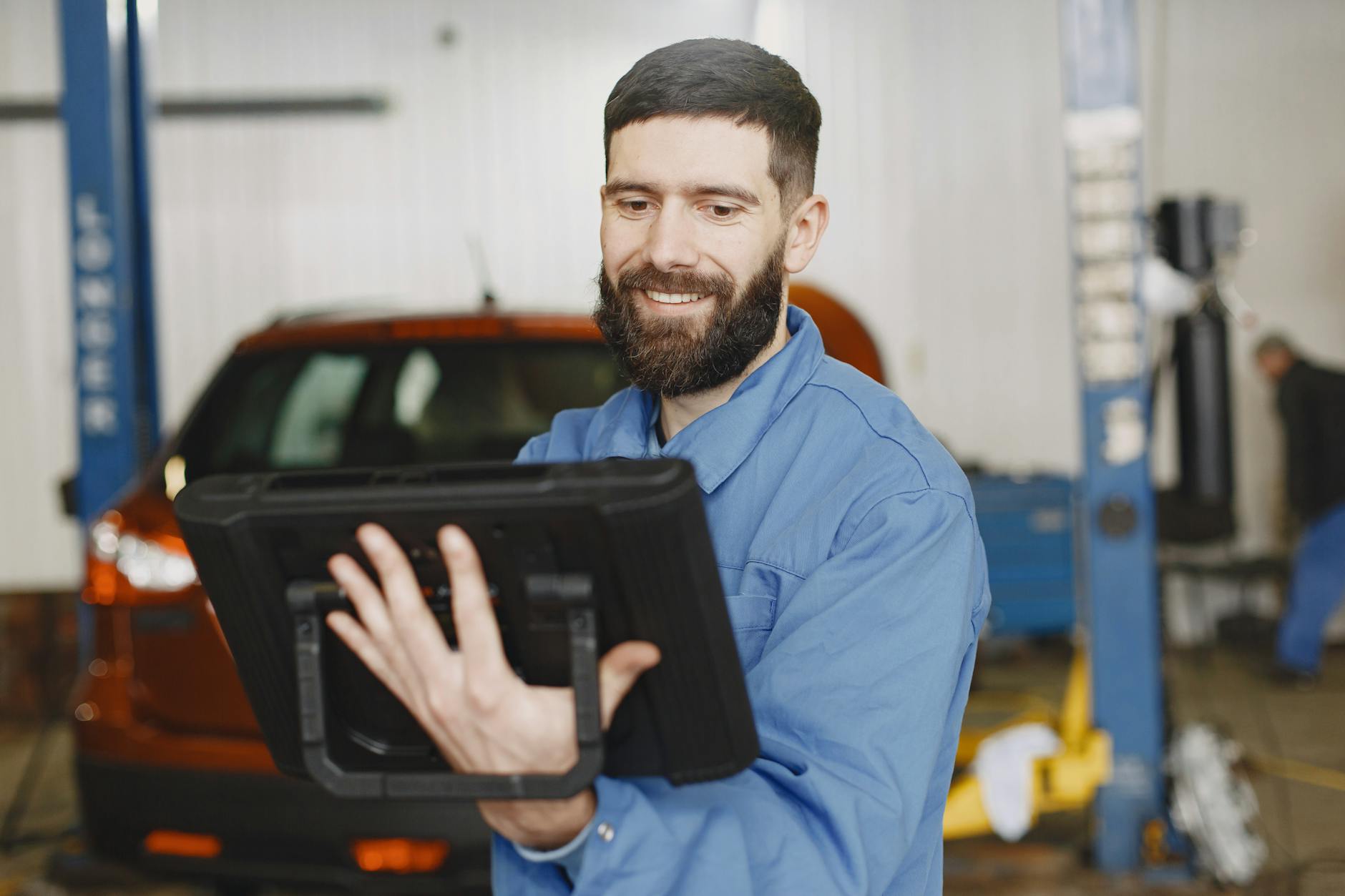Tecnico manutentore con tablet in stabilimento Manutentore consulta dashboard predittiva su tablet vicino a macchinario